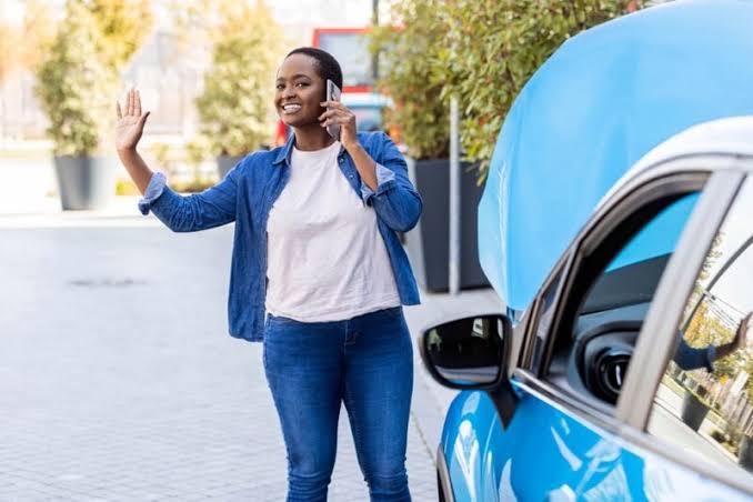 Driver waving for help beside a car with the hood open