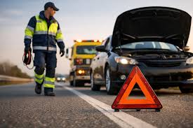 Roadside technician walking toward a disabled vehicle with its hood open